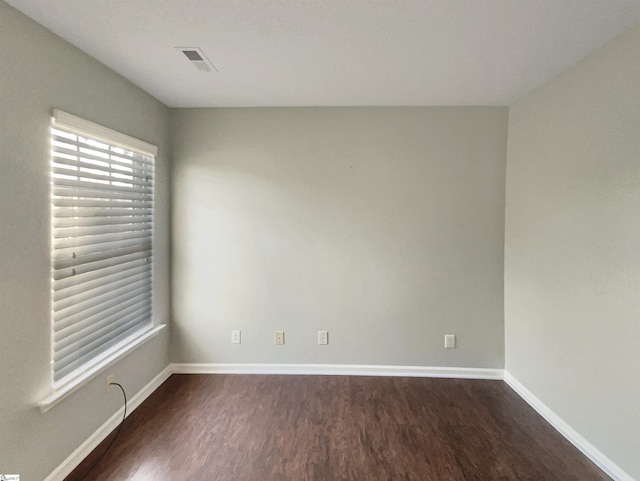 unfurnished room with dark wood-type flooring