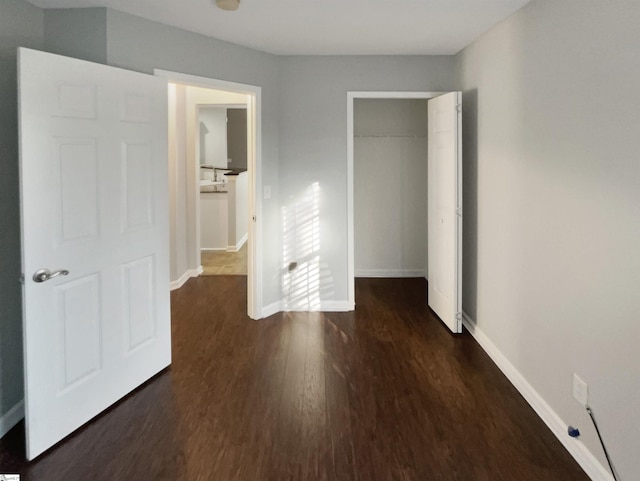 unfurnished bedroom with a closet and dark wood-type flooring