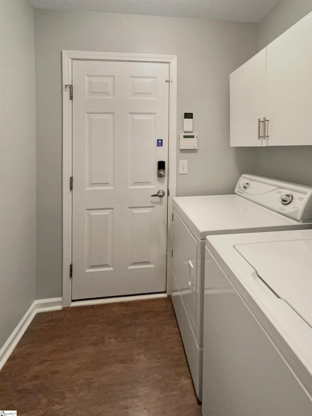 laundry area with cabinets, independent washer and dryer, and dark hardwood / wood-style flooring