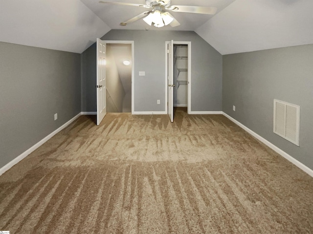 bonus room with ceiling fan, light colored carpet, and vaulted ceiling