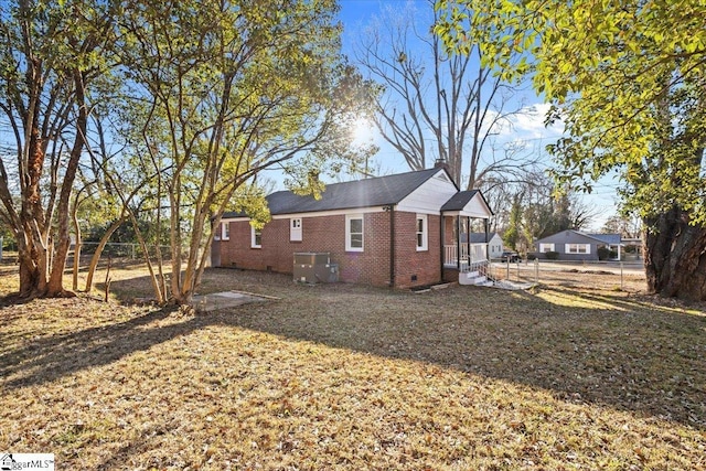 back of property featuring central AC and a lawn