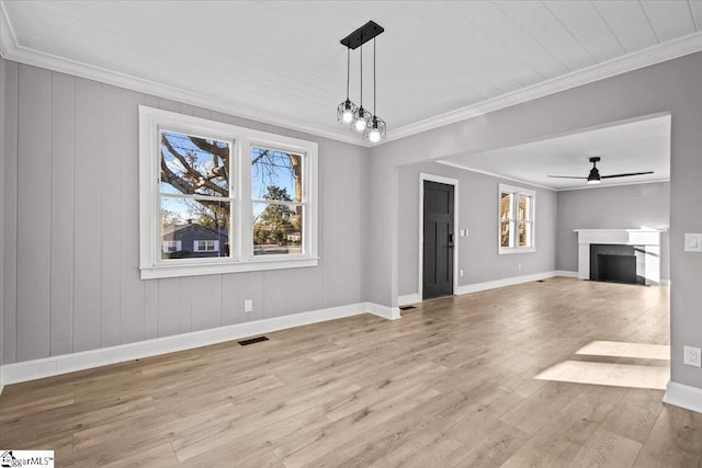 unfurnished living room featuring a wealth of natural light, ceiling fan, light hardwood / wood-style flooring, and ornamental molding