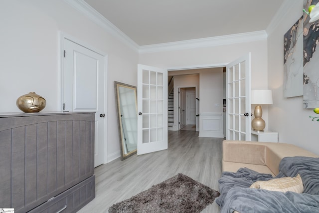 living room featuring ornamental molding, light hardwood / wood-style flooring, and french doors