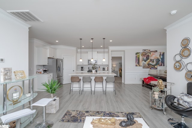 living room with crown molding and light hardwood / wood-style flooring