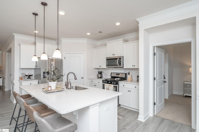 kitchen featuring sink, white cabinets, a center island with sink, and appliances with stainless steel finishes