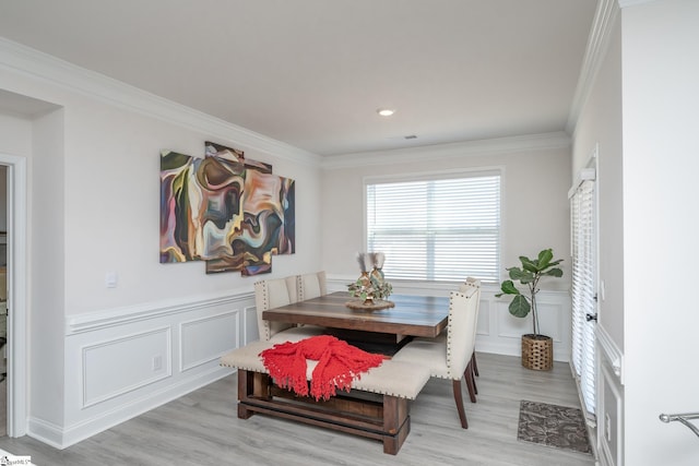 dining space featuring light wood-type flooring and ornamental molding