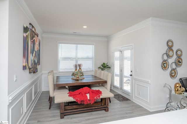 dining area featuring light wood-type flooring and ornamental molding