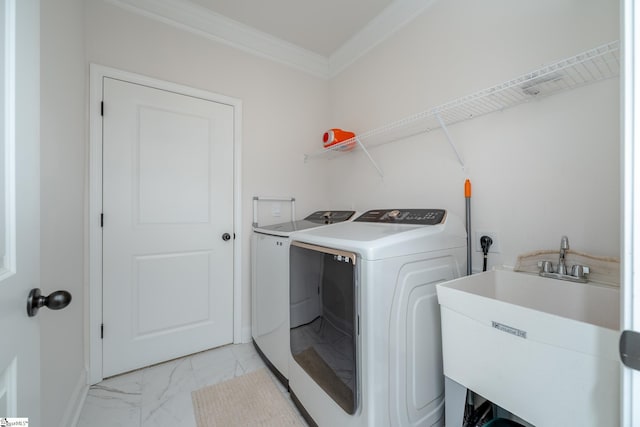 clothes washing area featuring washer and dryer, ornamental molding, and sink