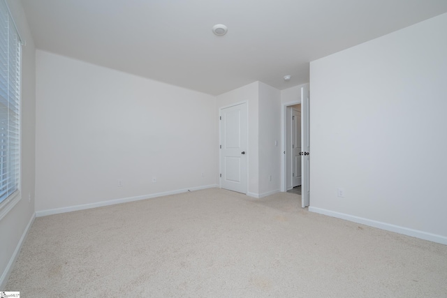 unfurnished room featuring light carpet