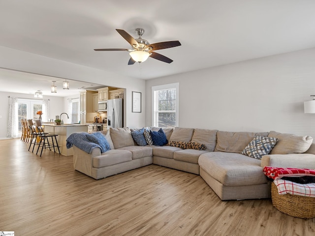 living room featuring a wealth of natural light, light hardwood / wood-style floors, and ceiling fan