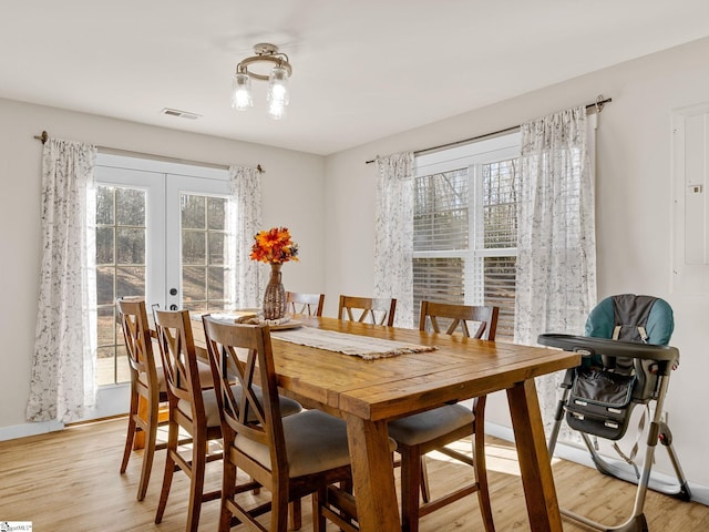 dining room featuring a wealth of natural light, french doors, and light wood-type flooring