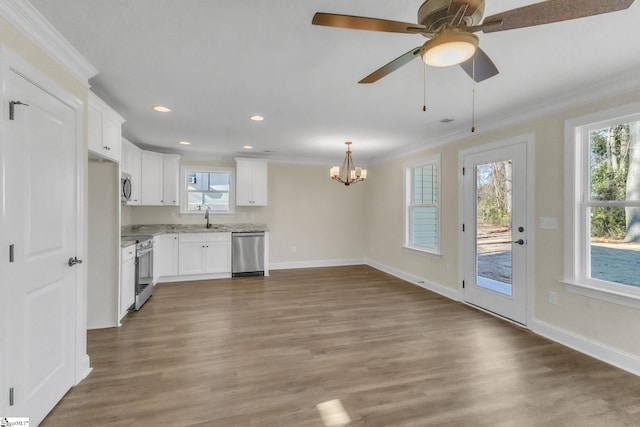 kitchen with white cabinets, sink, hardwood / wood-style flooring, ornamental molding, and appliances with stainless steel finishes