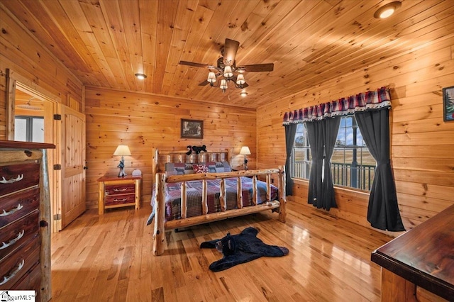 bedroom with wooden walls, light hardwood / wood-style floors, and wooden ceiling