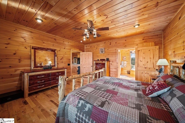 bedroom featuring ceiling fan, light hardwood / wood-style floors, wooden ceiling, and wooden walls