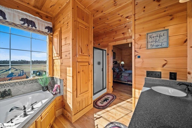 bathroom featuring wooden ceiling, a bath, sink, wooden walls, and hardwood / wood-style flooring