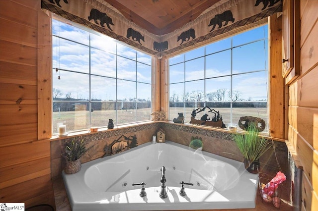 bathroom with a relaxing tiled tub, wood walls, wooden ceiling, and a wealth of natural light