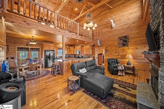 living room with wooden ceiling, high vaulted ceiling, beamed ceiling, a notable chandelier, and light hardwood / wood-style floors