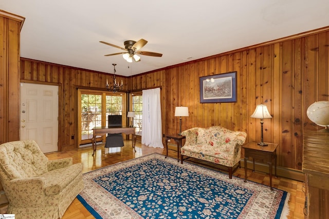 living room featuring ceiling fan with notable chandelier, light parquet flooring, and ornamental molding