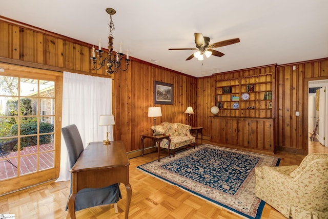 interior space featuring ceiling fan with notable chandelier, built in shelves, light parquet flooring, and wood walls