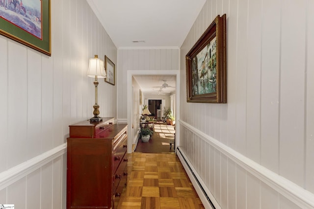 hall with ornamental molding, a baseboard heating unit, and parquet flooring