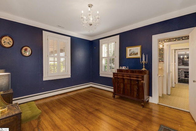 interior space featuring a baseboard heating unit, a notable chandelier, and hardwood / wood-style flooring