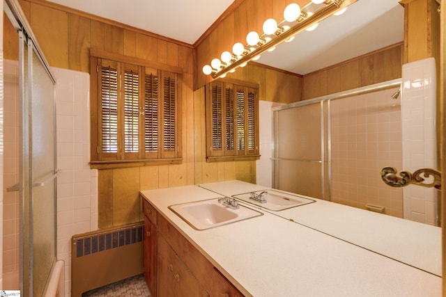 bathroom featuring radiator heating unit, vanity, an enclosed shower, and wood walls