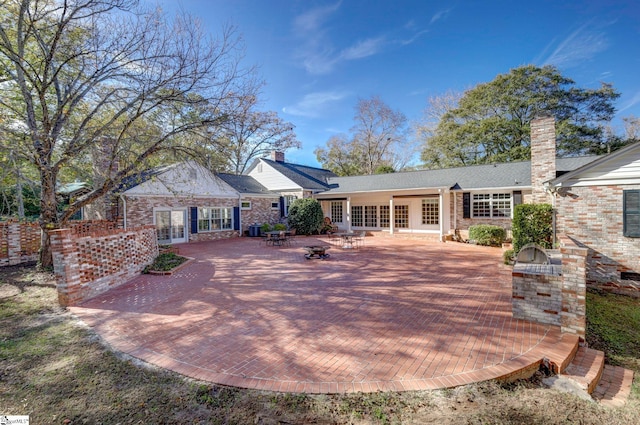 rear view of house featuring area for grilling and a patio area