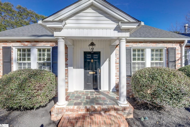 view of exterior entry featuring covered porch