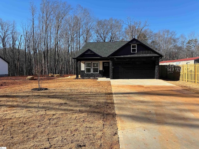 view of front of property with a garage, fence, and concrete driveway