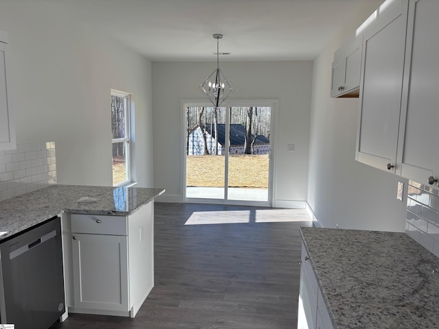 kitchen featuring dark wood-style floors, hanging light fixtures, backsplash, white cabinetry, and dishwasher