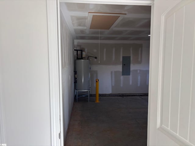 hallway with water heater, concrete flooring, attic access, and electric panel