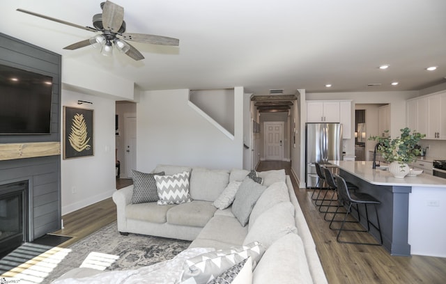 living room featuring ceiling fan, dark wood-type flooring, and sink