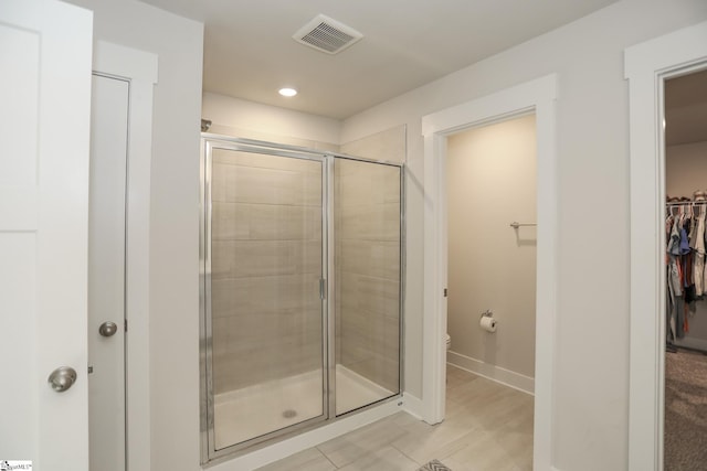 bathroom featuring toilet and an enclosed shower