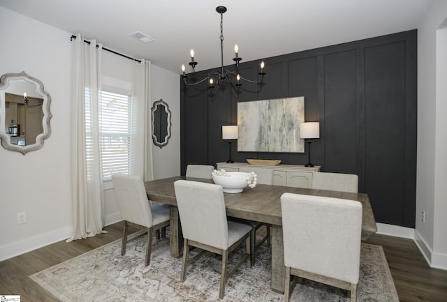 dining area with dark hardwood / wood-style flooring and a chandelier