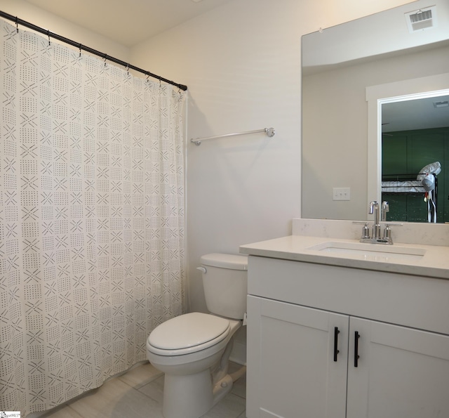 bathroom with tile patterned flooring, vanity, and toilet