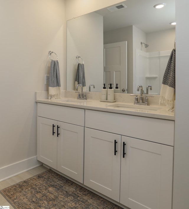 bathroom featuring hardwood / wood-style floors, vanity, and walk in shower