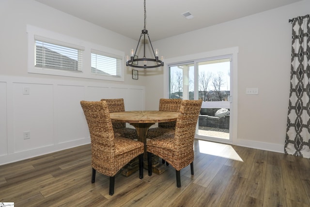 dining space featuring dark hardwood / wood-style floors and a notable chandelier