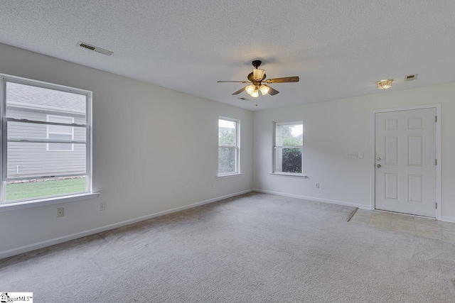 carpeted empty room featuring a textured ceiling and ceiling fan