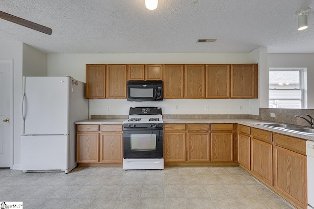 kitchen with a textured ceiling, ceiling fan, white appliances, and sink