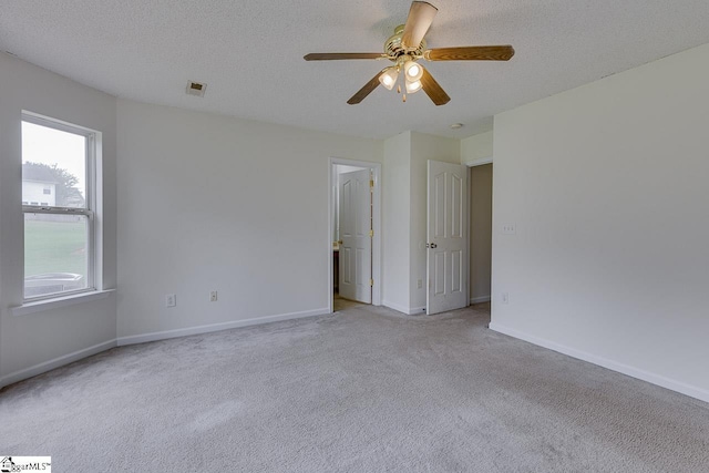 spare room with light carpet, a textured ceiling, and ceiling fan