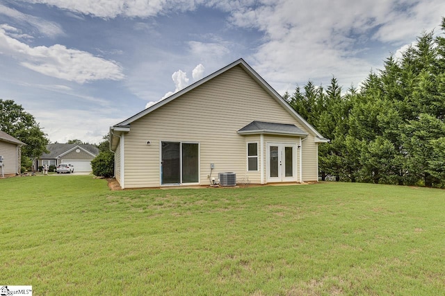 back of property with a lawn, central air condition unit, and french doors