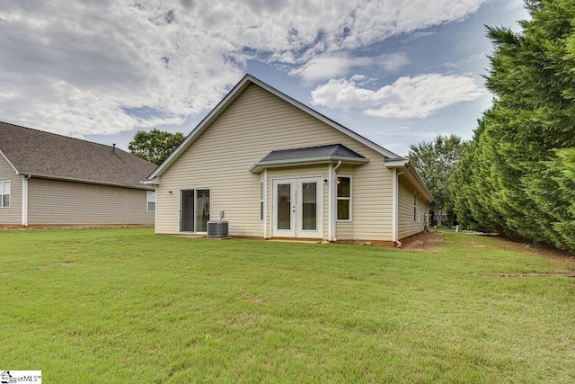 rear view of property with french doors, a yard, and central AC