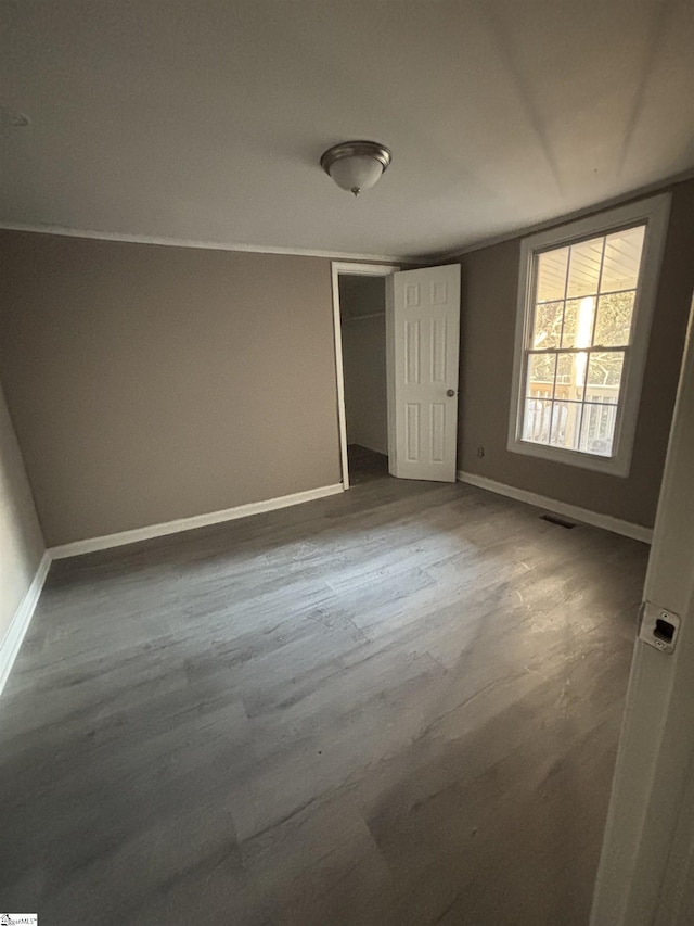 unfurnished bedroom featuring dark hardwood / wood-style flooring and a closet