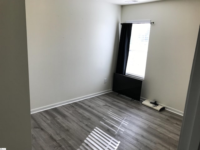 unfurnished room featuring plenty of natural light and dark hardwood / wood-style flooring