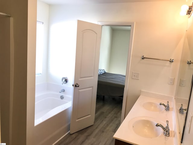 bathroom with a bathing tub, vanity, and wood-type flooring