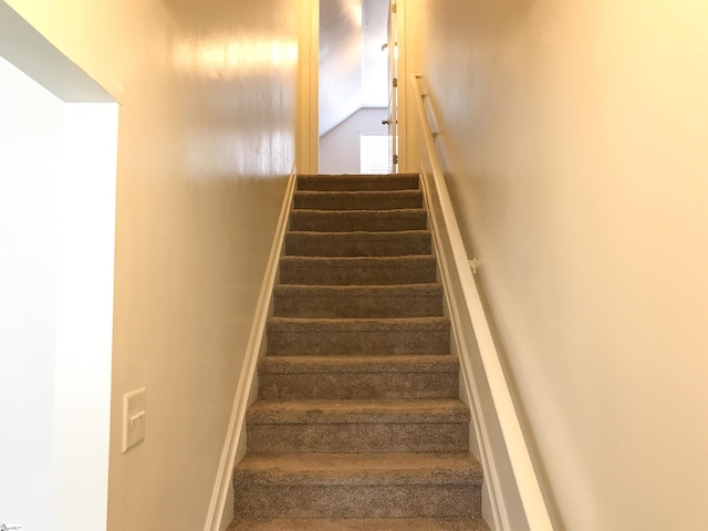 stairway featuring lofted ceiling