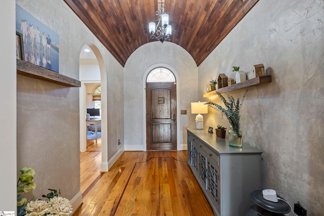 entryway featuring brick ceiling, a notable chandelier, vaulted ceiling, and hardwood / wood-style flooring