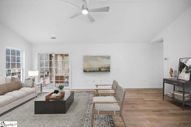 living room featuring hardwood / wood-style flooring, vaulted ceiling, and ceiling fan