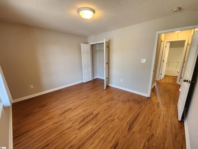 unfurnished bedroom with a closet, light hardwood / wood-style flooring, and a textured ceiling