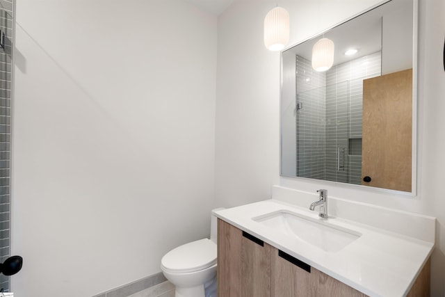 bathroom with a shower with door, vanity, and toilet